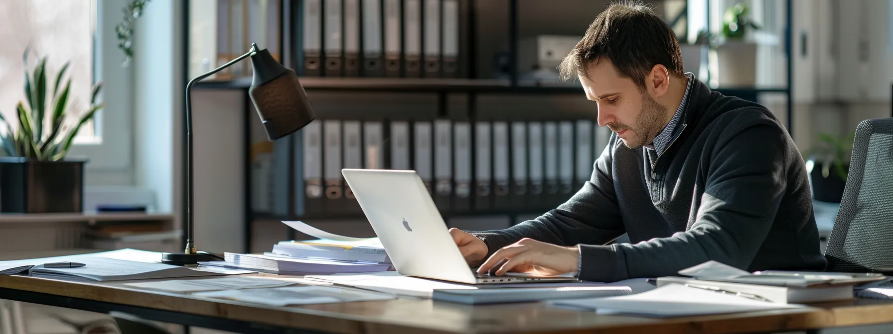 a professional office setting features a focused hvacr contractor seated at a sleek desk, surrounded by organized financial documents and a digital device displaying bond application forms, illustrating the meticulous process of preparing for contractor bonding.
